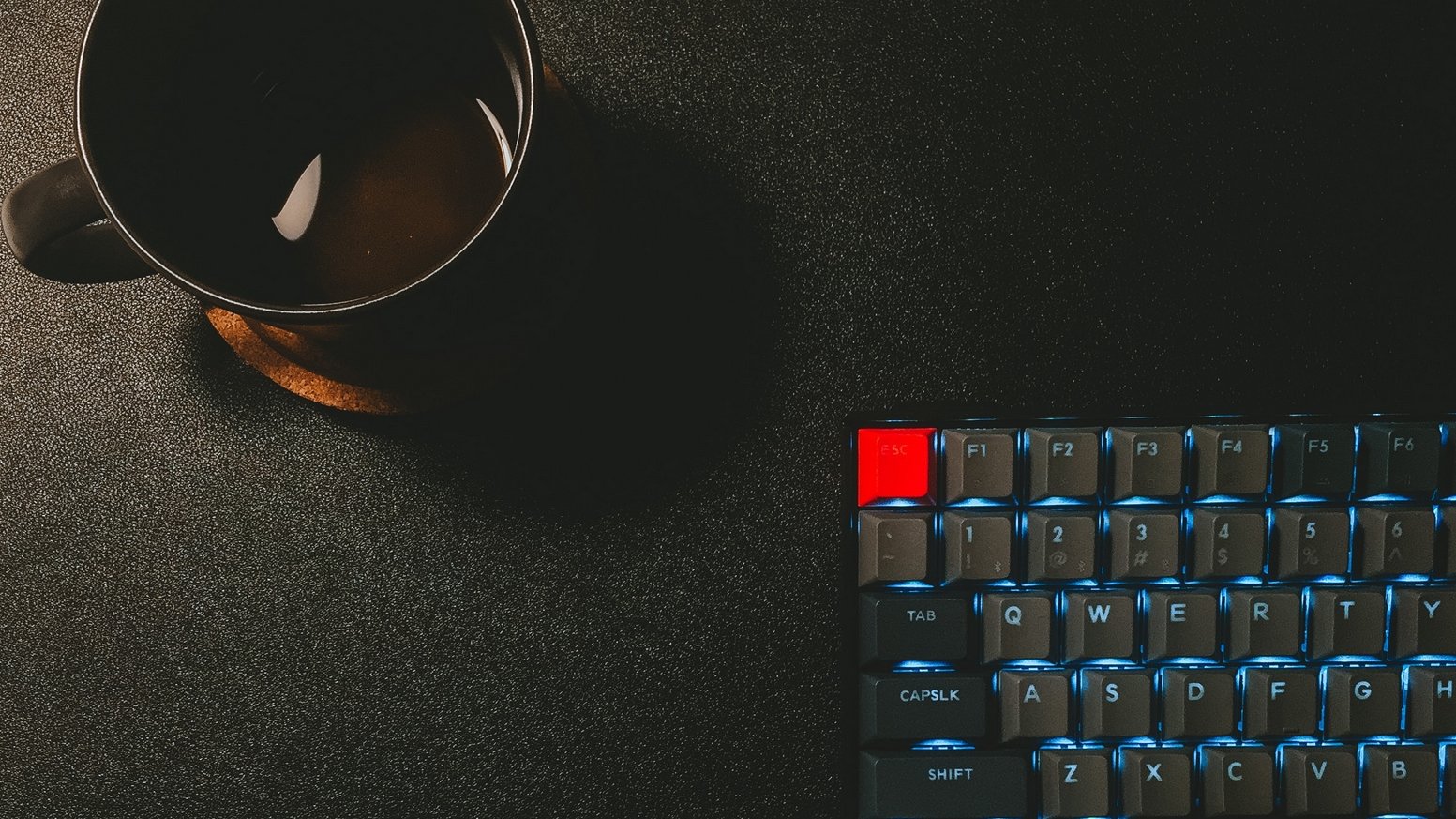 A computer keyboard, and an appetizing cup of coffee